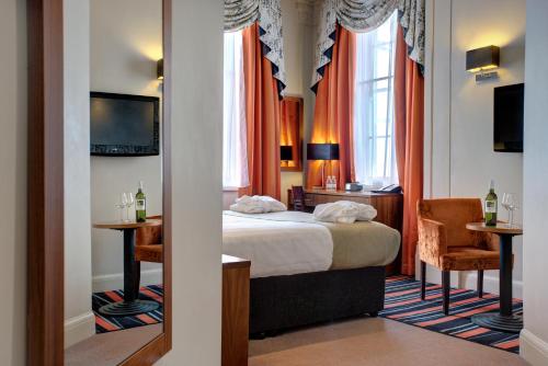 利物浦Heywood House Hotel, BW Signature Collection的酒店客房,配有一张床、一张桌子和椅子