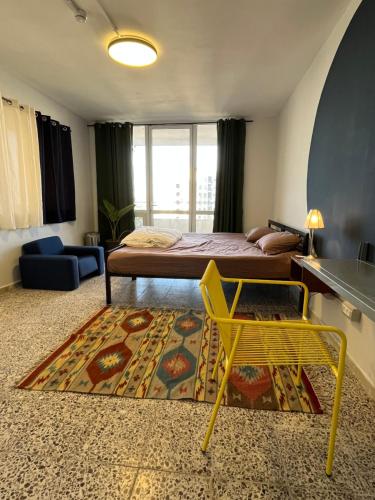 伯利恒Bethlehem City Hostel的一间卧室配有床、黄椅和地毯