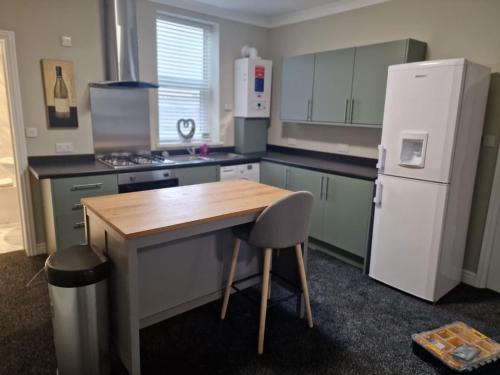 达灵顿Levy Nook 3的厨房配有木桌和冰箱。