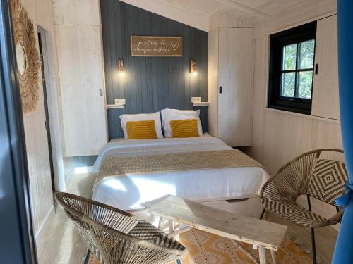 布里尼奥冈普拉格Camping de la côte des légendes的一间卧室配有一张床和两把椅子