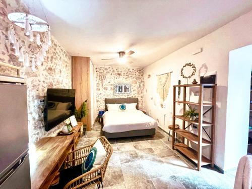 罗希姆诺Smyrni Rethymno Suites的一间卧室配有一张床,并在一间客房内配有电视。