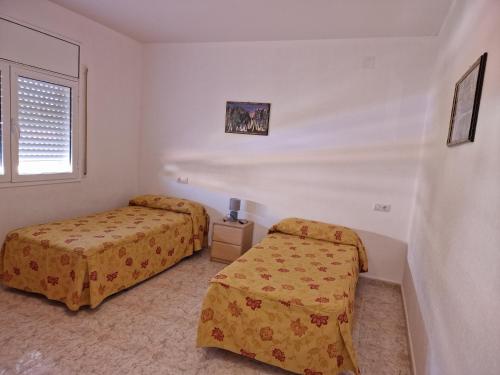 迈阿密普拉特亚Chalet Menorca的一间卧室设有两张床和窗户。