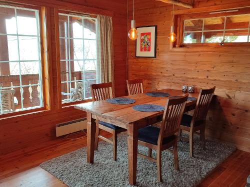 LauvstadCosy chalet, 100m2 with fjordview!的木制用餐室配有木桌和椅子