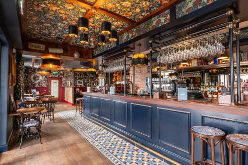 莱瑟姆-圣安妮Offshore - The Inn Collection Group的餐厅设有酒吧,配有桌椅