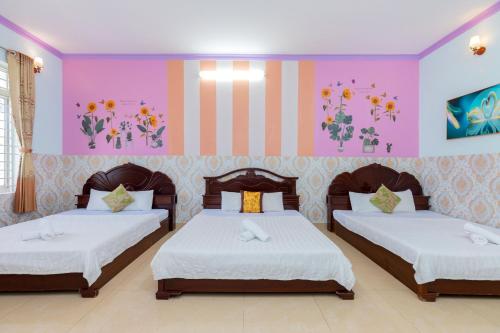 头顿Homestay Bảo Anh的配有粉红色和紫色墙壁的客房内的两张床