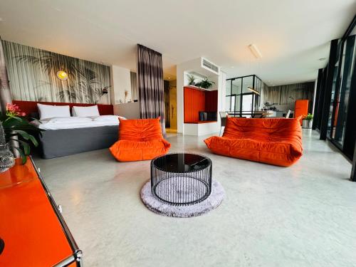 魏勒格Orange Lounge的客厅配有橙色家具和床