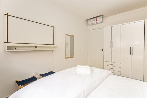 弗洛里亚诺波利斯Apto c/ churrasq. e piscina - quadra mar - RMI201的一间白色卧室,配有一张大床和一台电视
