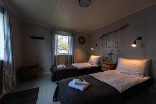 雷讷Cozy House By The Fjord In The Heart Of Lofoten的酒店客房设有两张床和窗户。