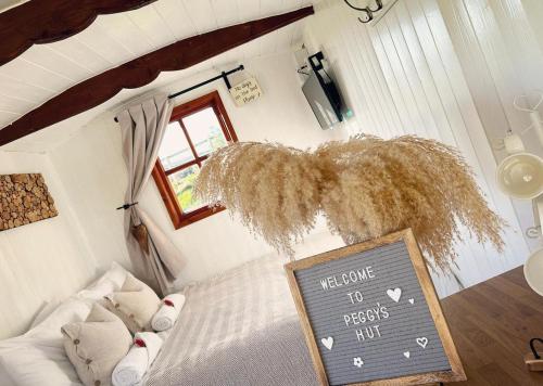 AstburyPeggy’s Hut的卧室配有粉笔板,欢迎客人尊重他的标志