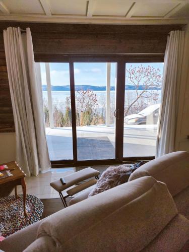 Saint-FulgenceSuite 3, Flèche du fjord, vue Saguenay, Mont Valin的带沙发和大窗户的客厅