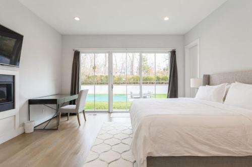 萨格港Villa Kimaal - Luxury with pool的一间卧室配有一张床、一张书桌和一个窗户。