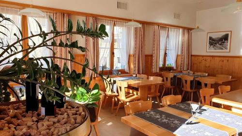 InnerferreraGasthaus Alpenrose的一间设有桌椅和盆栽的餐厅