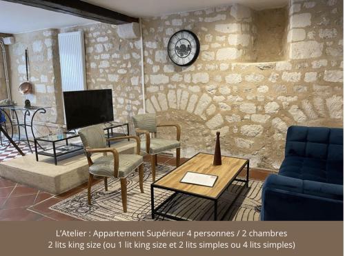 欧塞尔Le Pigeonnier centre historique Auxerre的客厅配有椅子和墙上的时钟