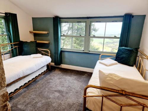 利斯卡德Wheal Tor Hotel & Glamping的带2扇窗户的客房内的2张床