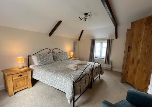 特鲁罗Maple & Beech Barns的一间卧室设有一张大床和一个窗户。