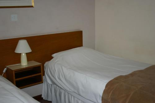 萨克斯特德农家宾馆的一间卧室配有两张床和床头灯。