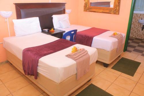卡萨内Luma Guest House的酒店客房,设有两张床和镜子