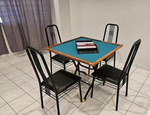 淡文Tambun Sunway Homestay的一张桌子,上面有四把椅子和一个蛋糕