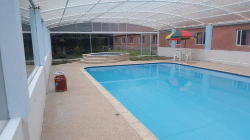 科塔卡奇HOSTERIA RANCHO SANTA FE的一座带遮阳伞的大型蓝色游泳池