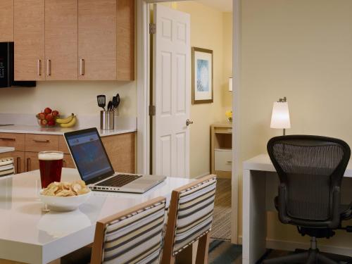 莫尔文Avia Residences on Lincoln - Extended Stay的厨房配有一张桌子,上面有一台笔记本电脑