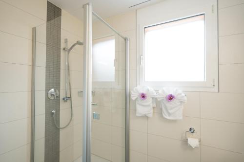 艾姆敦Apartment Elona的墙上设有淋浴和毛巾的浴室