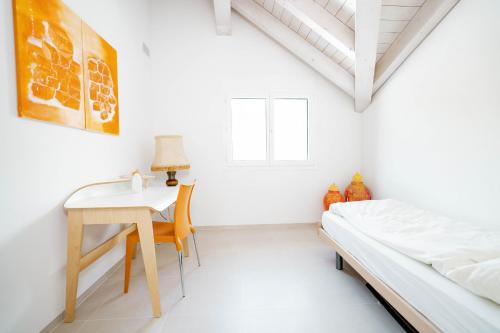 艾姆敦Apartment Soldanella的白色卧室配有书桌和床