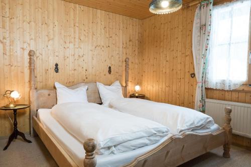 艾姆敦特莱斯亚度假屋的一间卧室配有一张带白色床单的床和一扇窗户。