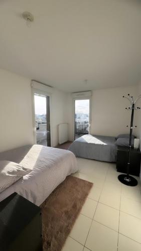 塞尔吉Chambres sur Cergy的白色客房的两张床,设有窗户