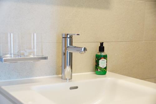艾姆敦Bijou am Bach的浴室水槽和水龙头旁的肥皂瓶
