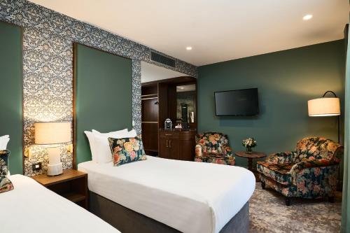 戈尔韦The House Hotel, an Ascend Hotel Collection Member的配有一张床和一把椅子的酒店客房