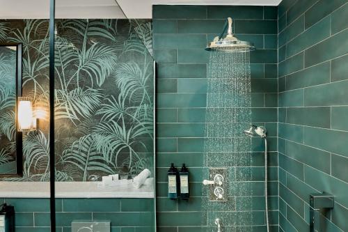 戈尔韦The House Hotel, an Ascend Hotel Collection Member的浴室设有蓝色瓷砖淋浴。