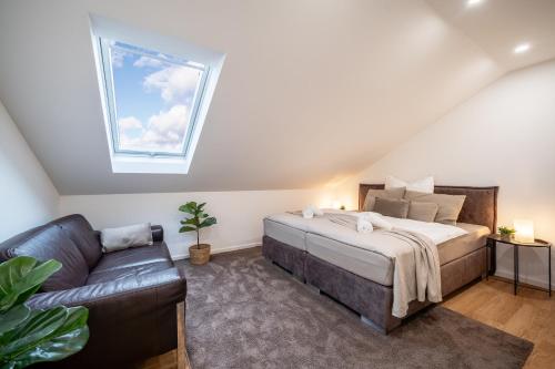比勒费尔德Apartment Milse - Modern. Stylisch的一间卧室配有一张床、一张沙发和一个窗口