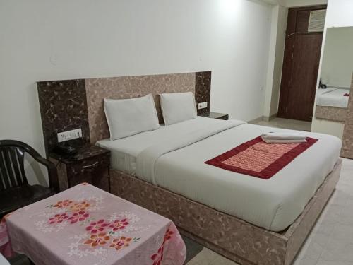 新德里gold stays hotel near IGI international airport的一间卧室配有一张大床和一张桌子