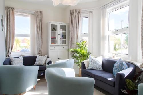 浦耳Poole Park House的客厅设有2张蓝色的沙发和窗户。
