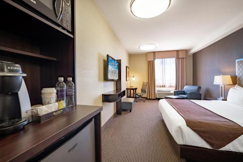 卡尔加里Acclaim Hotel by CLIQUE的酒店客房,配有床和电视