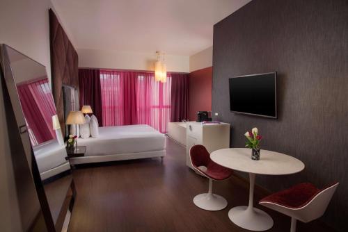 米兰诺奥米兰酒店的酒店客房配有一张床铺和一张桌子。