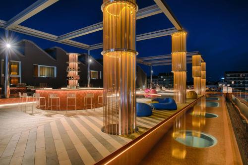 米兰诺奥米兰酒店的建筑中带圆柱和蓝色座椅的屋顶甲板