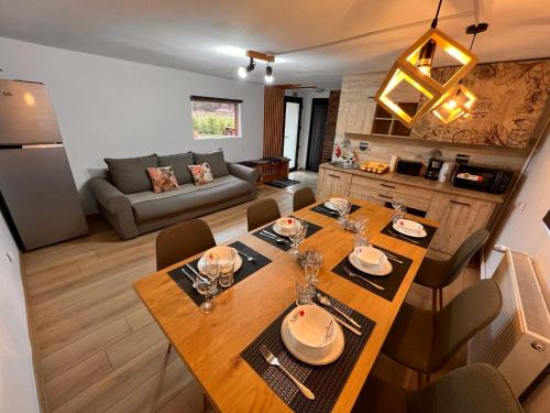 泽尔内什蒂View Piatra Craiului的厨房以及带木桌和椅子的客厅。