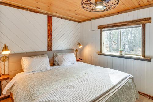 德卢斯Waterfront Duluth Cabin with Deck and River View!的一间带床的卧室,位于带窗户的房间内