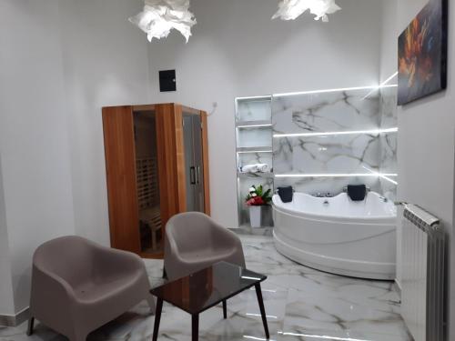 贝尔格莱德Authentic Belgrade Centre - Luxury Suites的带浴缸、椅子和桌子的浴室
