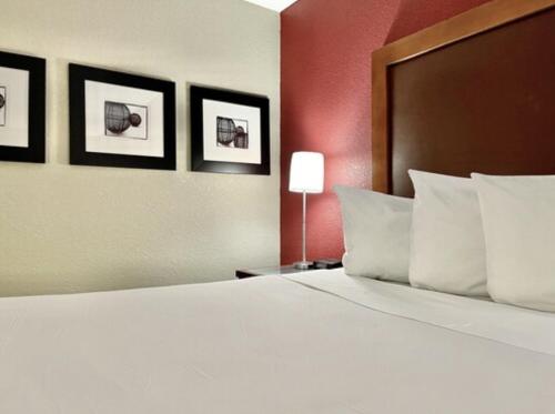 韦恩堡FairBridge Inn & Suites Fort Wayne的卧室配有一张白色大床,墙上挂有三张照片