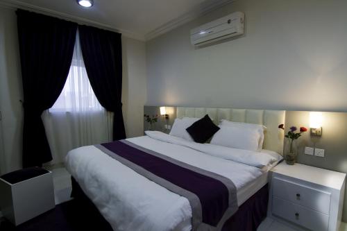利雅德Rofan Hotel Suites的一间设有大床和窗户的酒店客房
