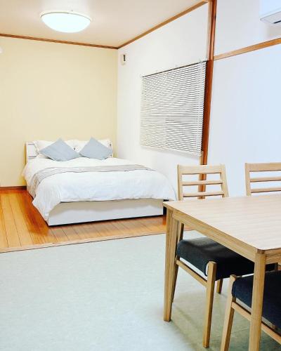 日田市Hita hostel - Vacation STAY 07583v的卧室配有一张床和一张桌子及椅子