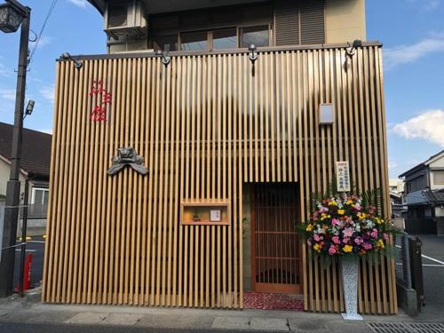 日田市Hita hostel - Vacation STAY 07583v的木结构建筑,人行道上有一扇门和鲜花