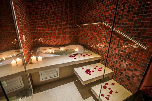 佩洛塔斯Motel I Love Pelotas的浴室设有浴缸和红色瓷砖淋浴。