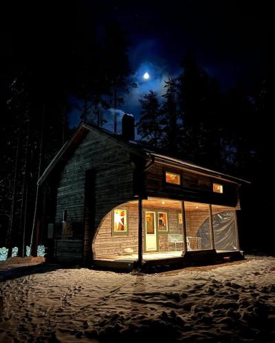 马隆Cabin in the Woods的天空中月亮的夜晚房屋