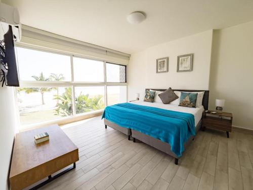 蓬塔查梅Sanctuary by Playa Caracol Residences的一间卧室设有一张大床和一个大窗户