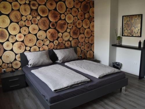 诺伊基兴Nice apartment in Neuenkirchen的一张位于一个木墙的房间的床位