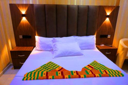 PokuaseTexas Royal Hotel的一间卧室配有一张带木制床头板的床