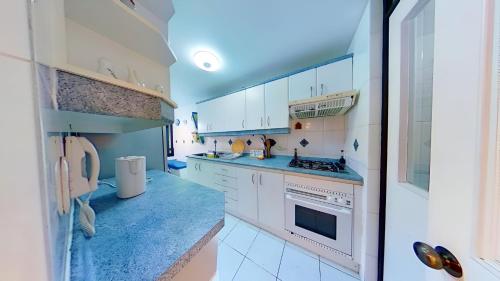 阿尔加罗沃Altos de San Alfonso的厨房配有白色橱柜和蓝色台面